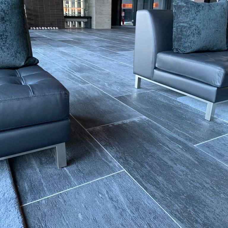 Feature image for Black Schist - Interior Flooring. The image shows this product being used in an interior floor application. The surface finish shown is honed. Dominant colors shown are black and gray. The color mix creates a cool feeling.