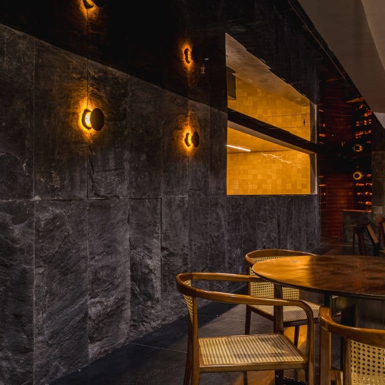 Application image for Midnight Black Brazilian Gneiss - Cut to Size Veneer. The image shows this product being used in a full bed veneer application. The surface finish shown is split-face. The dominant color shown is black. The color mix creates a warm feeling.