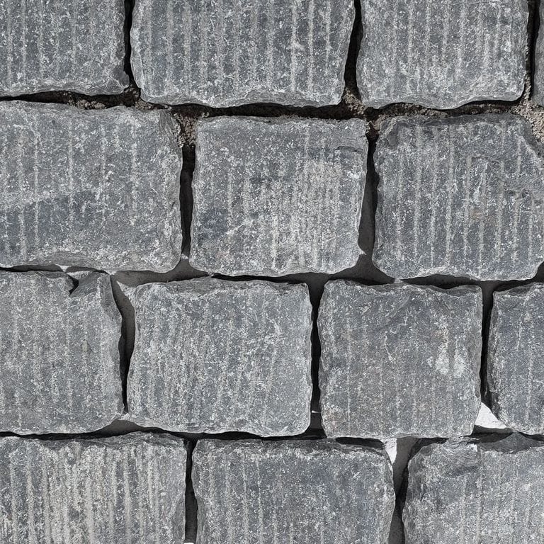 Color/Finish variation image for Reclaimed Black Granite - Grooved Cobblestone. The surface finish shown is grooved. Dominant colors shown are black and gray. The color mix creates a cool feeling.