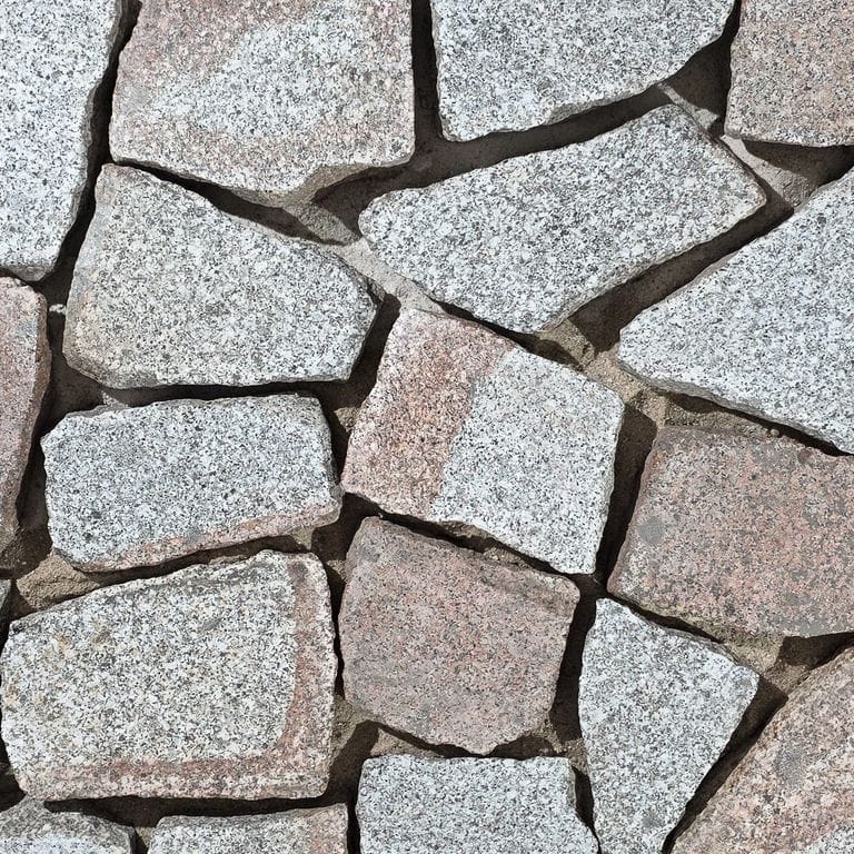 Color/Finish variation image for Reclaimed Polygonal Granite Cobblestones - Flamed Surface. The surface finish shown is flamed. Dominant colors shown are gray and pink.