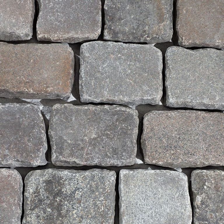 Color/Finish variation image for Reclaimed Multicolor Granite Cobblestones - Worn Surface. The surface finish shown is . Dominant colors shown are gray and tan. The color mix creates a warm feeling.