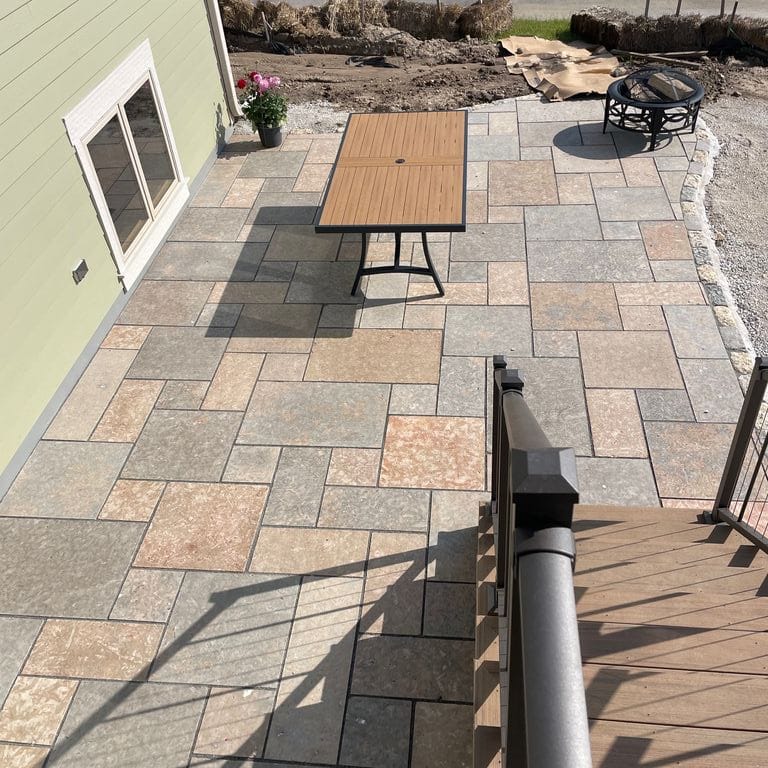 Feature image for Madison Full Color Limestone - Pavers. The image shows this product being used for landscape curbing &amp; edging, patio pavers and treads. The surface finish shown is flamed. Dominant colors shown are gray and tan; with beige, blue, purple, white and cream secondaries. The color mix creates a warm feeling. Regular and cloudy color patterns. Contains mineral inclusions.