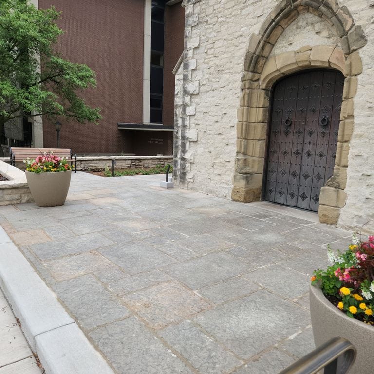 Application image for Madison Full Color Limestone - Pavers. The image shows this product being used in a patio pavers application. The surface finish shown is flamed. Dominant colors shown are gray and pink. The color mix creates a warm feeling.
