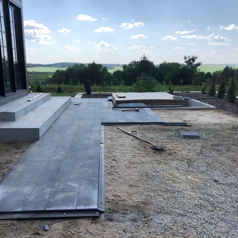 Application image for Superior Northern Granite - Pavers. The image shows this product being used in a patio pavers application. Dominant colors shown are black and gray. The color mix creates a cool feeling.