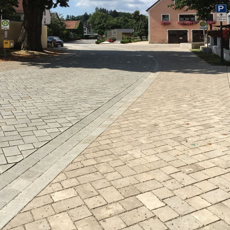 Application image for Bavarian Dolomite Gray Limestone - Cobblestone Paver. The image shows this product being used in a public area application. Dominant colors shown are beige, gray and tan. The color mix creates a warm feeling.