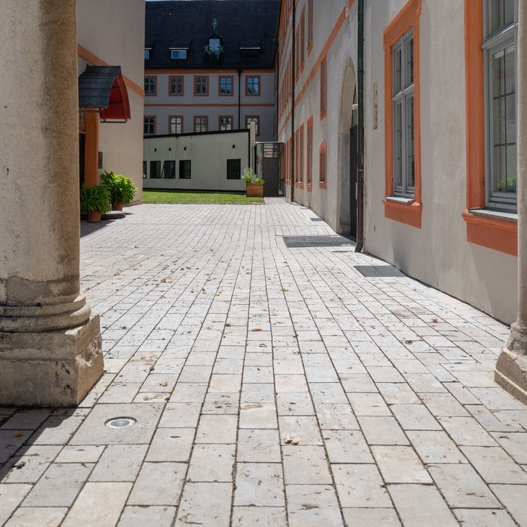 Application image for Bavarian Dolomite Gray Limestone - Cobblestone Paver. The image shows this product being used in a path pavers application. Dominant colors shown are gray and tan. The color mix creates a warm feeling.