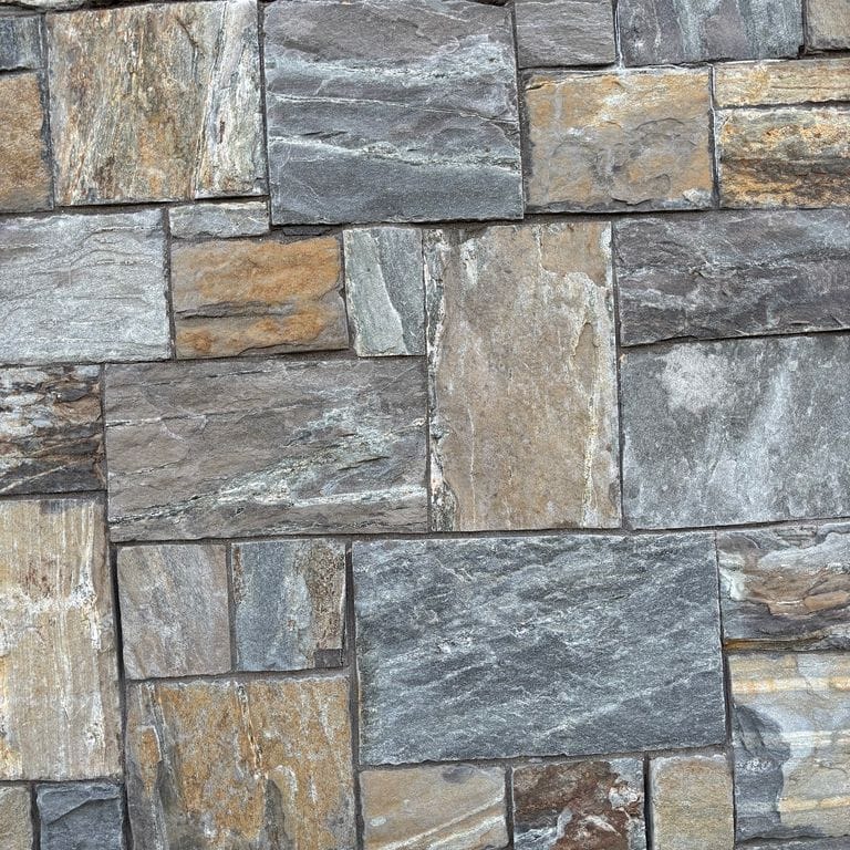 Application image for Mystic Mountain Granite - Natural Surface Veneer. The image shows this product being used for full bed veneer and thin veneer. The surface finish shown is natural. The dominant color shown is gray. The color mix creates a warm feeling.