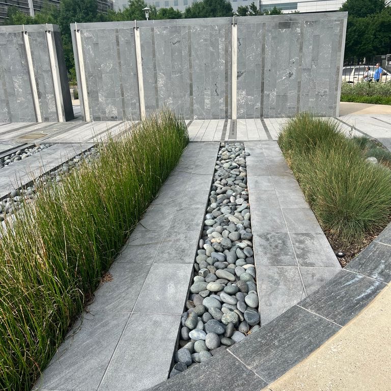 Application image for Strata Mist Cross-Cut Gneiss - Cut to Size Veneer. The image shows this product being used for patio pavers, full bed veneer, thin veneer and public area. The dominant color shown is gray.