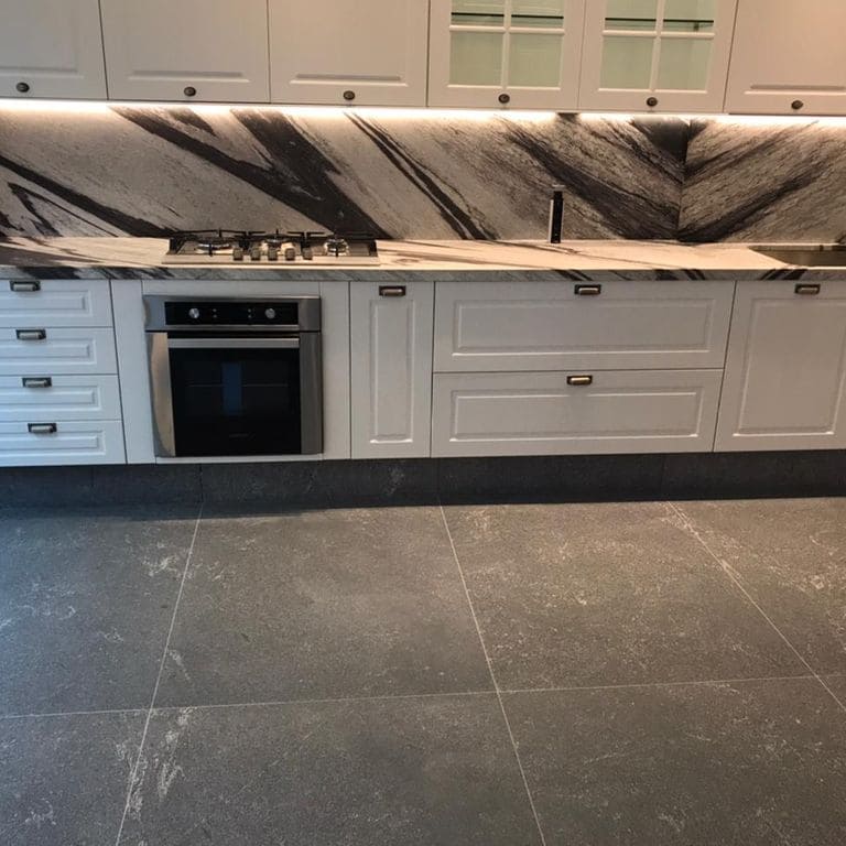 Application image for Strata Mist Cross-Cut Gneiss - Interior Flooring. The image shows this product being used in an interior floor application. The surface finish shown is honed. Dominant colors shown are black and gray.