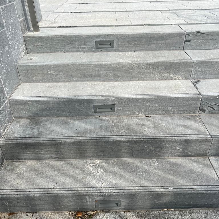 Application image for Strata Mist Cross-Cut Gneiss - Steps and Treads. The image shows this product being used in a monolithic steps application. The dominant color shown is gray. The color mix creates a cool feeling.