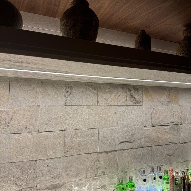 Feature image for Strata Snow Gneiss - Cut to Size Veneer. The image shows this product being used in an interior cladding application. The surface finish shown is split-face. The dominant color shown is white.