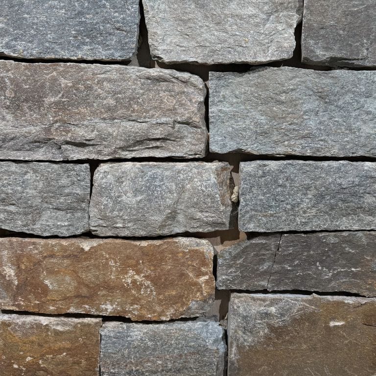 Color/Finish variation image for Quaker Hill Granite - Thin Veneer. The surface finish shown is split-face. Dominant colors shown are brown, gray and tan. The color mix creates a warm feeling.