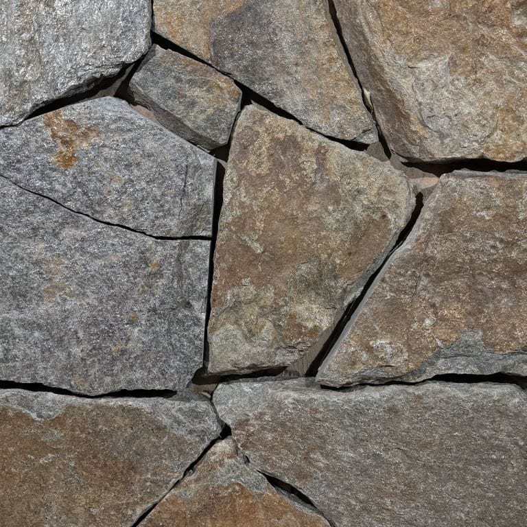 Color/Finish variation image for Quaker Hill Granite - Thin Veneer. The surface finish shown is split-face. Dominant colors shown are brown, gray and tan. The color mix creates a warm feeling.