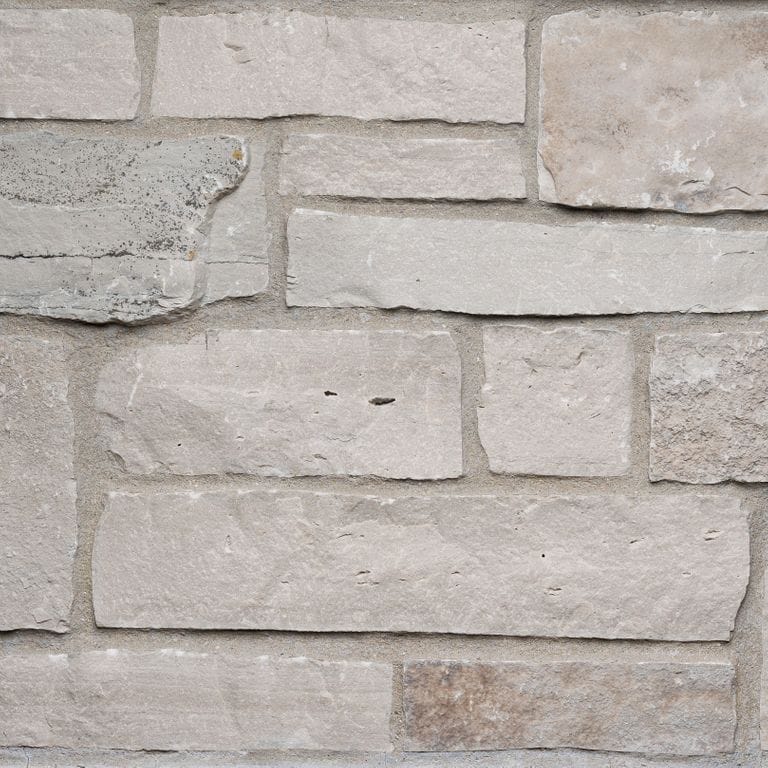 Best close-up image for Fond du Lac Colonial Limestone - Thin Veneer. The surface finish shown is split-face. The dominant color shown is gray. The color mix creates a warm feeling.