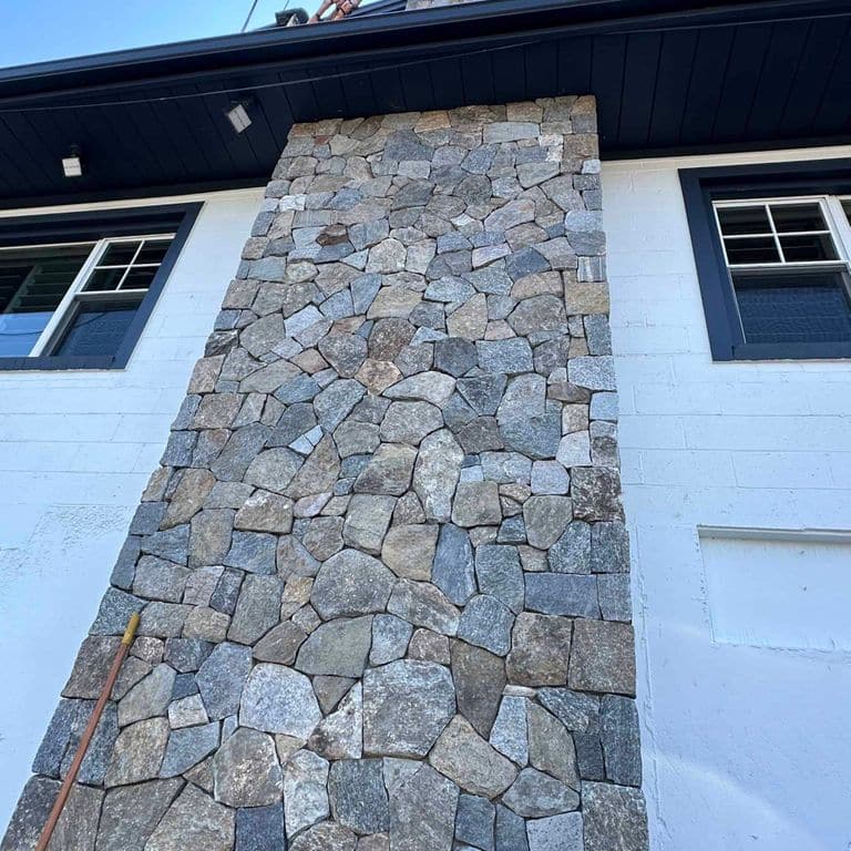 Application image for Boston Blend Granite Veneer - Mosaic. The image shows this product being used in a full bed veneer application. The surface finish shown is . The dominant color shown is gray. The color mix creates a cool feeling.