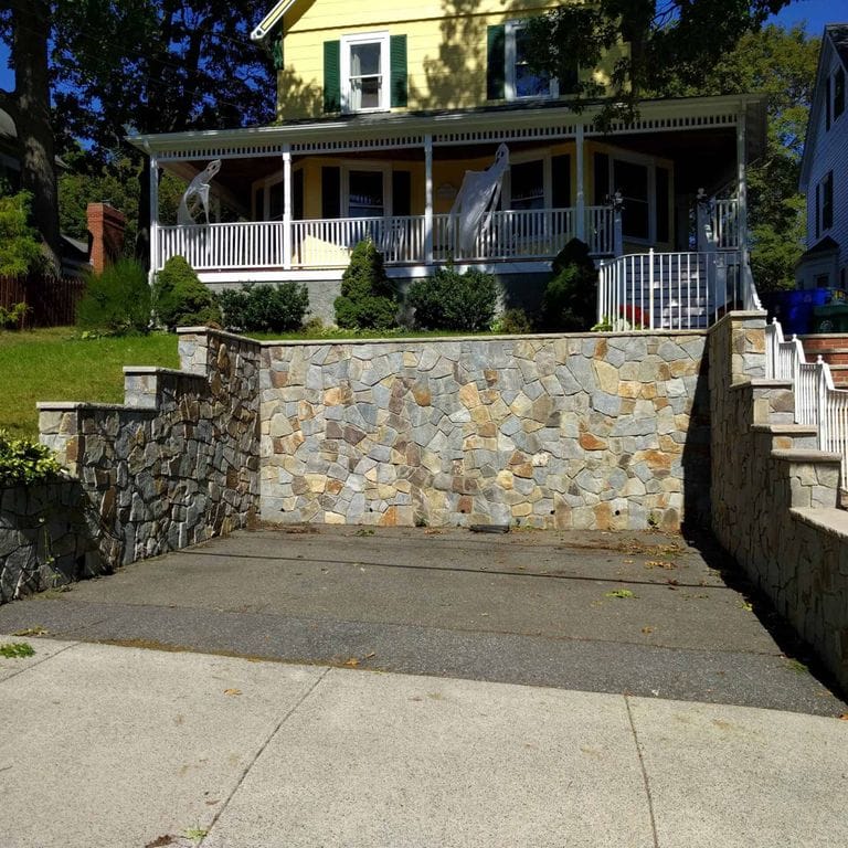 Application image for Boston Blend Granite Veneer - Mosaic. The image shows this product being used in a full bed veneer application. The surface finish shown is . Dominant colors shown are gray and tan. The color mix creates a warm feeling.