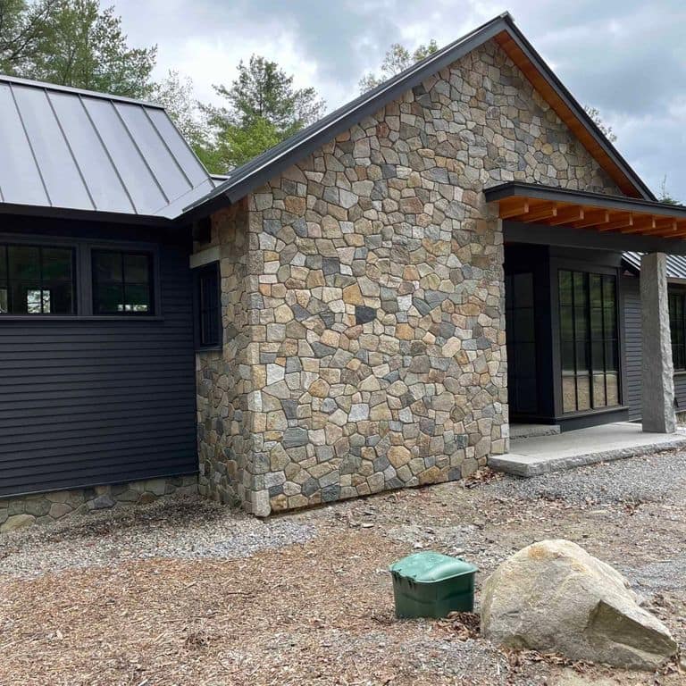 Application image for Boston Blend Granite Veneer - Mosaic. The image shows this product being used in a full bed veneer application. The surface finish shown is . The dominant color shown is gray. The color mix creates a warm feeling.