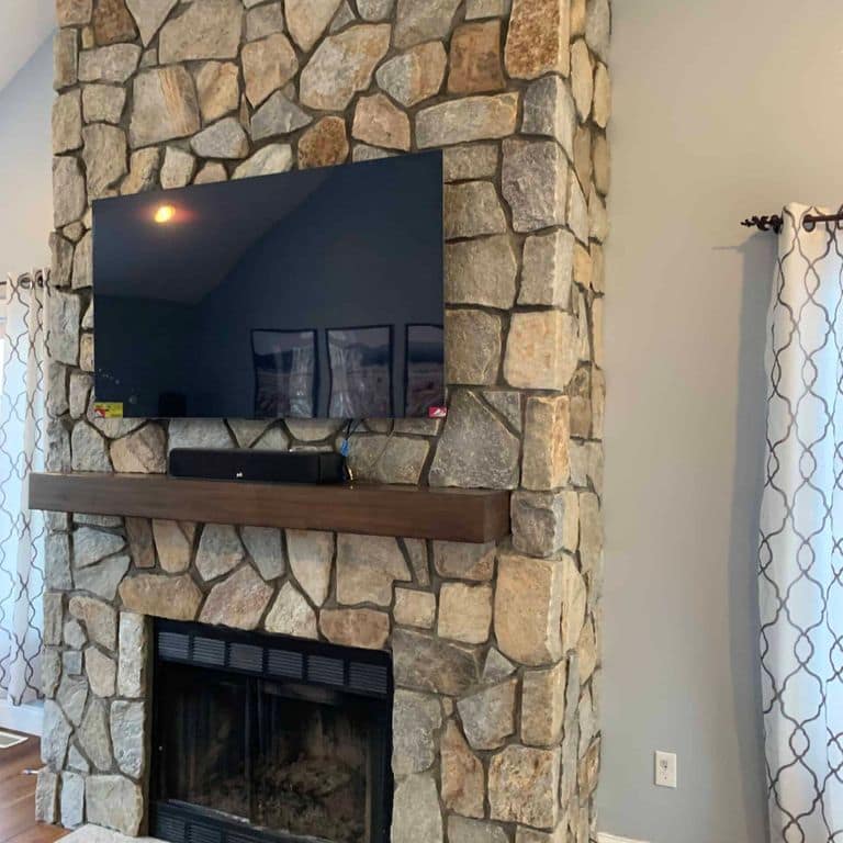 Application image for Newport Mist Granite Veneer - Mosaic. The image shows this product being used for fireplace surround and thin veneer. The surface finish shown is . Dominant colors shown are gray and tan. The color mix creates a warm feeling.