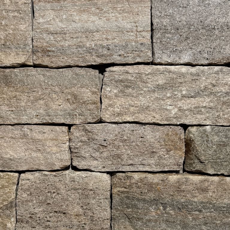 Color/Finish variation image for New England Tan Granite - Thin Veneer. The surface finish shown is split-face. Dominant colors shown are brown, gray and tan. The color mix creates a warm feeling.