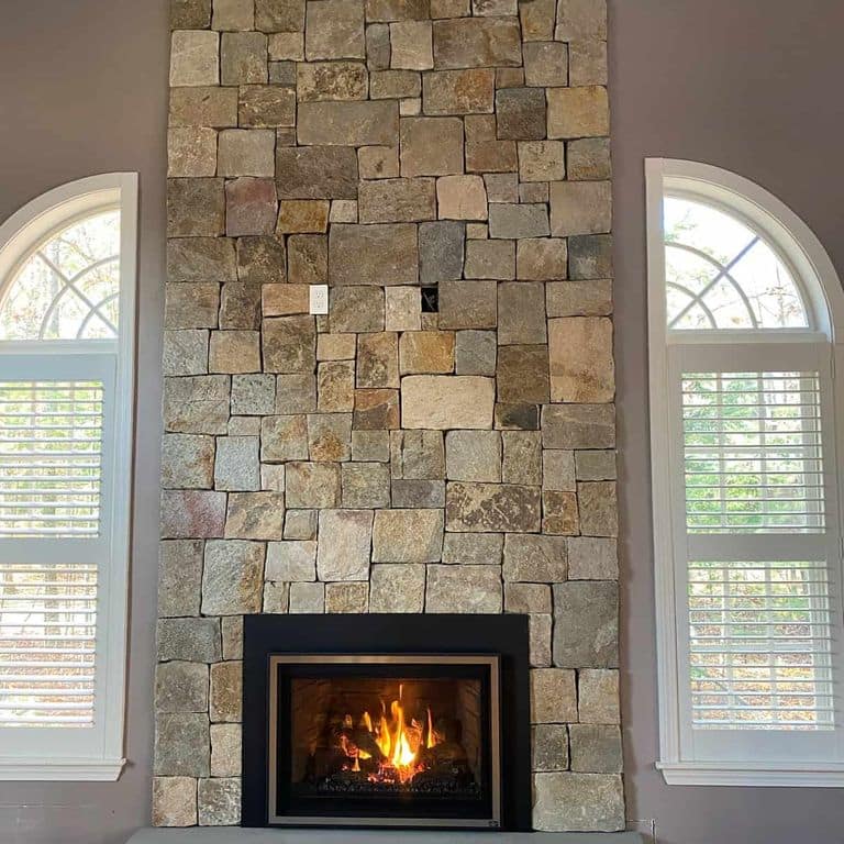 Application image for New England Tan Granite - Thin Veneer. The image shows this product being used for fireplace surround and thin veneer. The surface finish shown is . Dominant colors shown are brown and tan. The color mix creates a warm feeling.