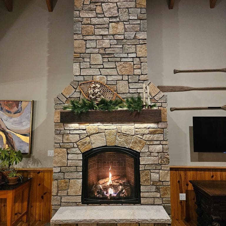 Application image for New England Tan Granite - Thin Veneer. The image shows this product being used for fireplace surround and thin veneer. The surface finish shown is split-face. Dominant colors shown are brown and tan. The color mix creates a warm feeling.