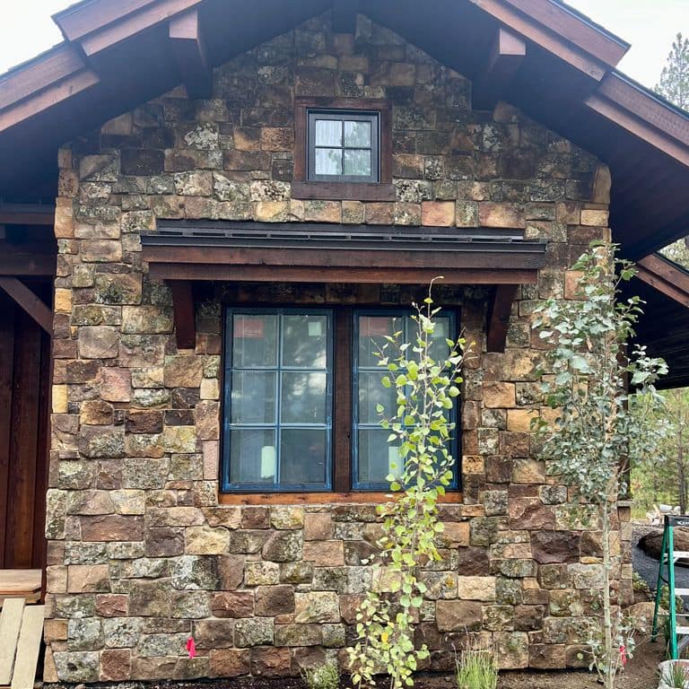 Feature image for Montana Moss Rock - Veneer. The image shows this product being used in a full bed veneer application. Dominant colors shown are brown and gray. The color mix creates a warm feeling.