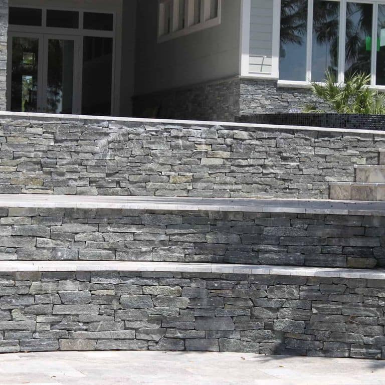 Application image for Greenwich Gray Granite Veneer - Ledge. The image shows this product being used in a thin veneer application. The surface finish shown is split-face. The dominant color shown is gray. The color mix creates a cool feeling.