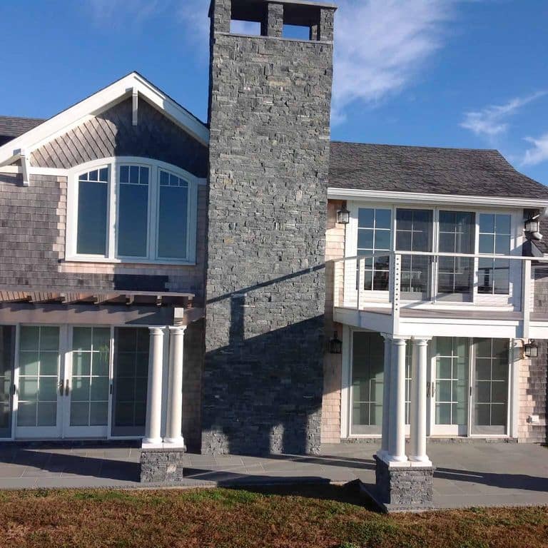 Application image for Greenwich Gray Granite Veneer - Ledge. The image shows this product being used in a full bed veneer application. The surface finish shown is split-face. The dominant color shown is gray.