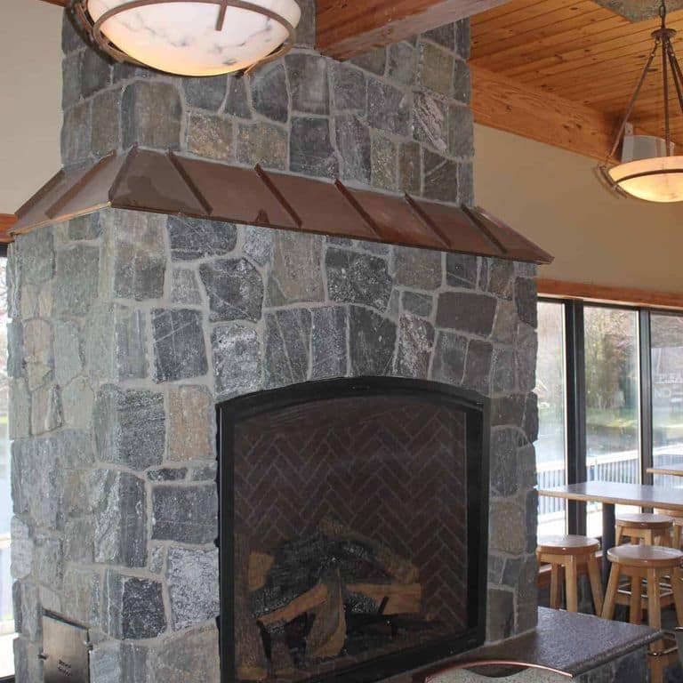 Application image for Greenwich Gray Granite Veneer - Square and Rectangle. The image shows this product being used for fireplace surround and thin veneer. The surface finish shown is . The dominant color shown is gray. The color mix creates a cool feeling.