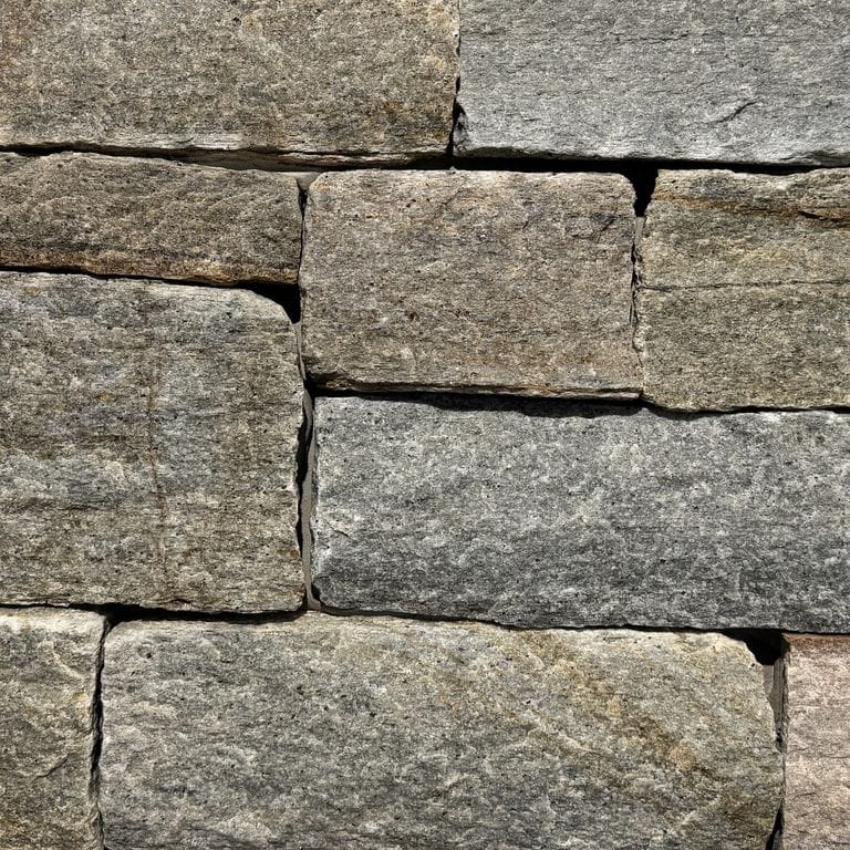 Color/Finish variation image for Newport Mist Granite Veneer - Ashlar. The surface finish shown is split-face. Dominant colors shown are gray and tan. The color mix creates a warm feeling.