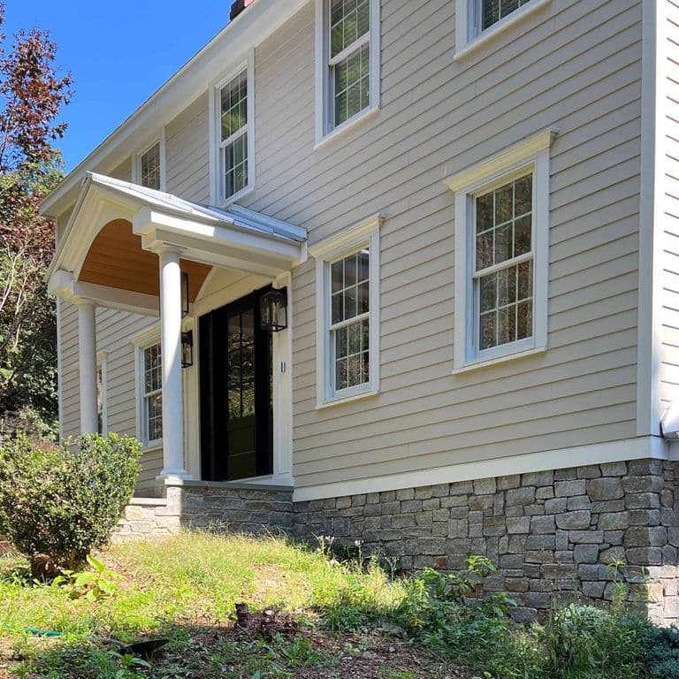 Application image for Newport Mist Granite Veneer - Ashlar. The image shows this product being used in a full bed veneer application. The surface finish shown is split-face. The dominant color shown is gray. The color mix creates a warm feeling.