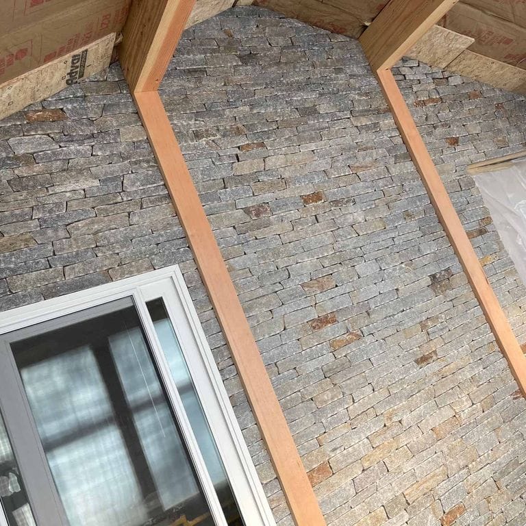 Application image for Newport Mist Granite Veneer - Ledge. The image shows this product being used in a thin veneer application. The surface finish shown is split-face. Dominant colors shown are gray and tan. The color mix creates a warm feeling.