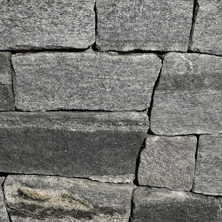 Color/Finish variation image for Oyster Bay Granite Thin Veneer - Ashlar. The surface finish shown is split-face. The dominant color shown is gray. The color mix creates a cool feeling.