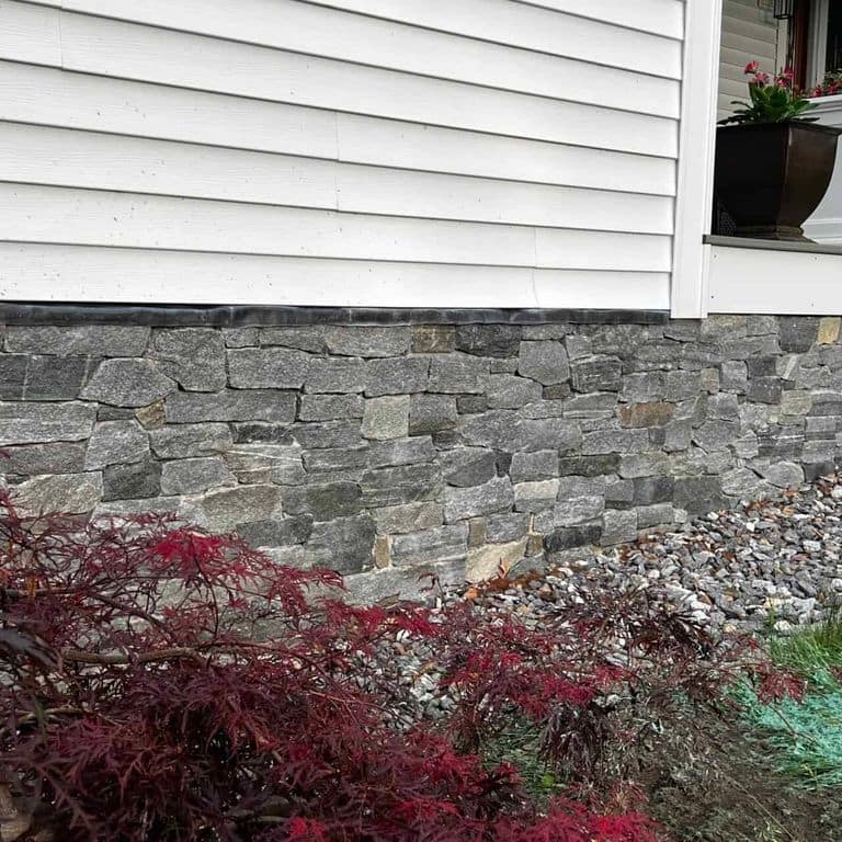 Application image for Oyster Bay Granite Thin Veneer - Ledge. The image shows this product being used in a thin veneer application. The surface finish shown is split-face. The dominant color shown is gray. The color mix creates a cool feeling.