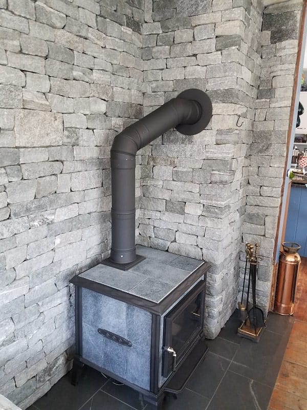 Application image for Oyster Bay Granite Thin Veneer - Ledge. The image shows this product being used in a thin veneer application. The surface finish shown is split-face. The dominant color shown is gray. The color mix creates a cool feeling.