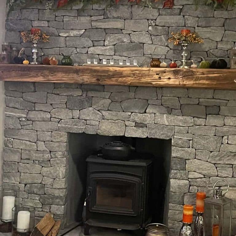 Application image for Oyster Bay Granite Thin Veneer - Ledge. The image shows this product being used for fireplace surround and thin veneer. The surface finish shown is split-face. The dominant color shown is gray. The color mix creates a cool feeling.