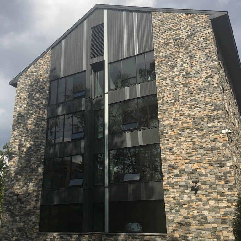 Application image for Boston Blend Granite Thin Veneer - Ashlar. The image shows this product being used in a full bed veneer application. The surface finish shown is split-face. Dominant colors shown are gray and tan. The color mix creates a warm feeling.