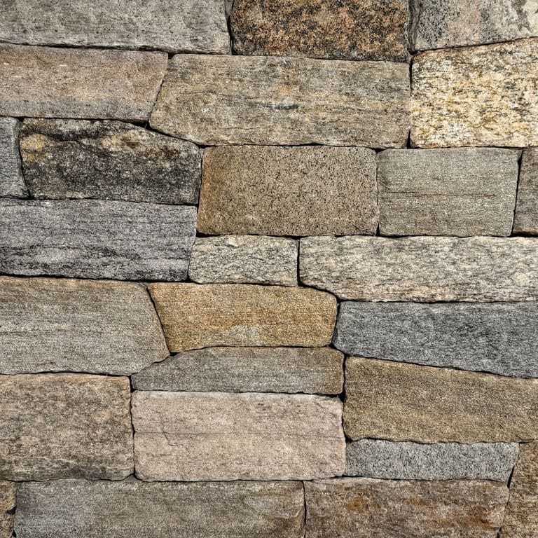 Color/Finish variation image for Boston Blend Granite Veneer - Ledge. The surface finish shown is split-face. Dominant colors shown are brown, gray and tan. The color mix creates a warm feeling.