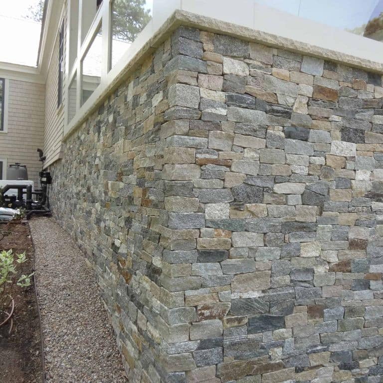 Application image for Boston Blend Granite Veneer - Ledge. The image shows this product being used in a thin veneer application. The surface finish shown is split-face. Dominant colors shown are gray and tan. The color mix creates a warm feeling.