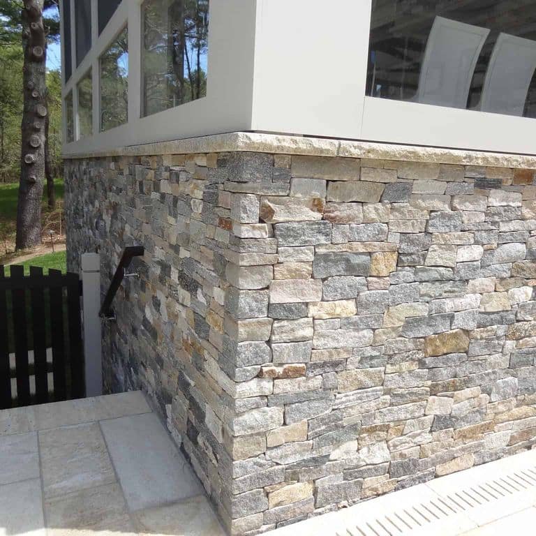 Application image for Boston Blend Granite Veneer - Ledge. The image shows this product being used in a full bed veneer application. The surface finish shown is split-face. Dominant colors shown are gray and tan. The color mix creates a warm feeling.