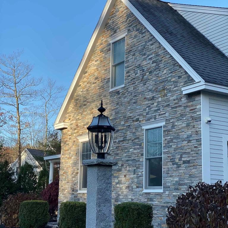 Application image for Boston Blend Granite Veneer - Ledge. The image shows this product being used in a full bed veneer application. The surface finish shown is split-face. The dominant color shown is gray. The color mix creates a cool feeling.