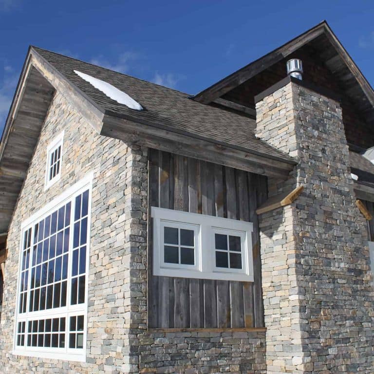 Application image for Boston Blend Granite Veneer - Ledge. The image shows this product being used in a full bed veneer application. The surface finish shown is split-face. The dominant color shown is gray. The color mix creates a cool feeling.