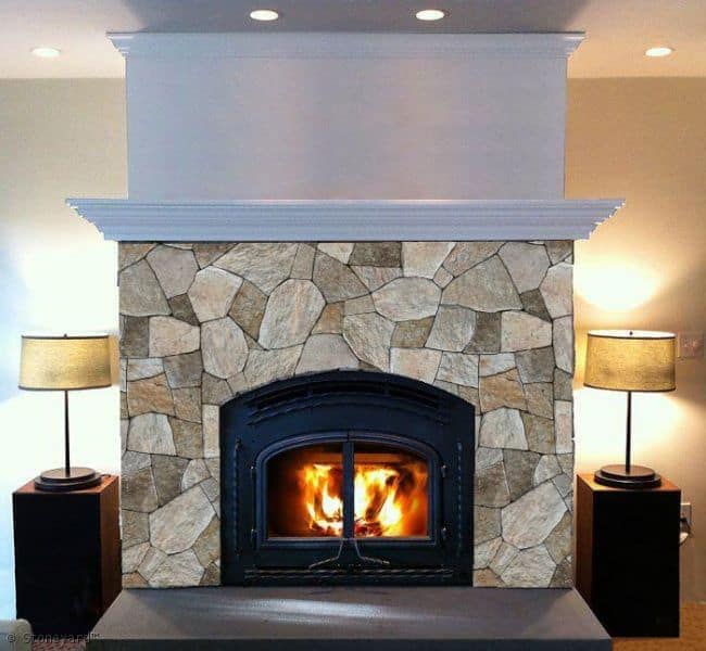 Application image for New England Tan Granite Veneer - Mosaic. The image shows this product being used for fireplace surround and thin veneer. The surface finish shown is . Dominant colors shown are gray and tan. The color mix creates a warm feeling.