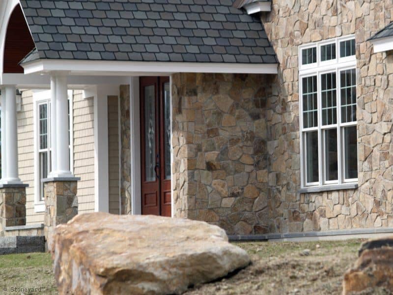 Application image for New England Tan Granite Veneer - Mosaic. The image shows this product being used in a full bed veneer application. The surface finish shown is . Dominant colors shown are gray and tan. The color mix creates a warm feeling.