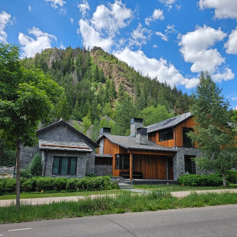 Feature image for Rocky Mountain Granite - Veneer. The image shows this product being used in a full bed veneer application. The surface finish shown is split-face. The dominant color shown is gray.