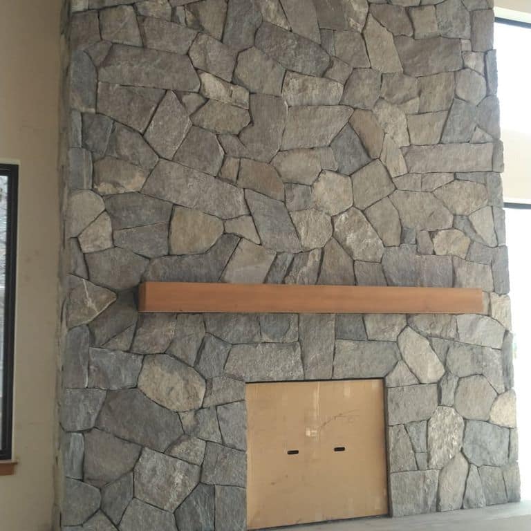 Application image for Rocky Mountain Granite - Veneer. The image shows this product being used in a full bed veneer application. The surface finish shown is split-face. The dominant color shown is gray. The color mix creates a warm feeling.