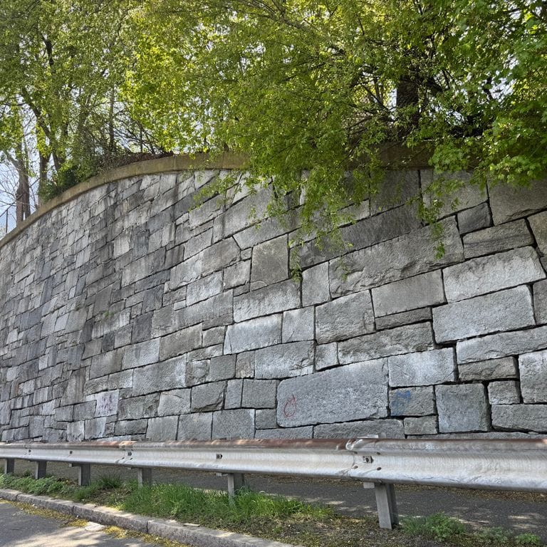 Application image for Test Record - Reclaimed Granite - Wallstone. The image shows this product being used for landscape wallstone and retaining wall. The surface finish shown is weathered. The dominant color shown is gray. The color mix creates a warm feeling.