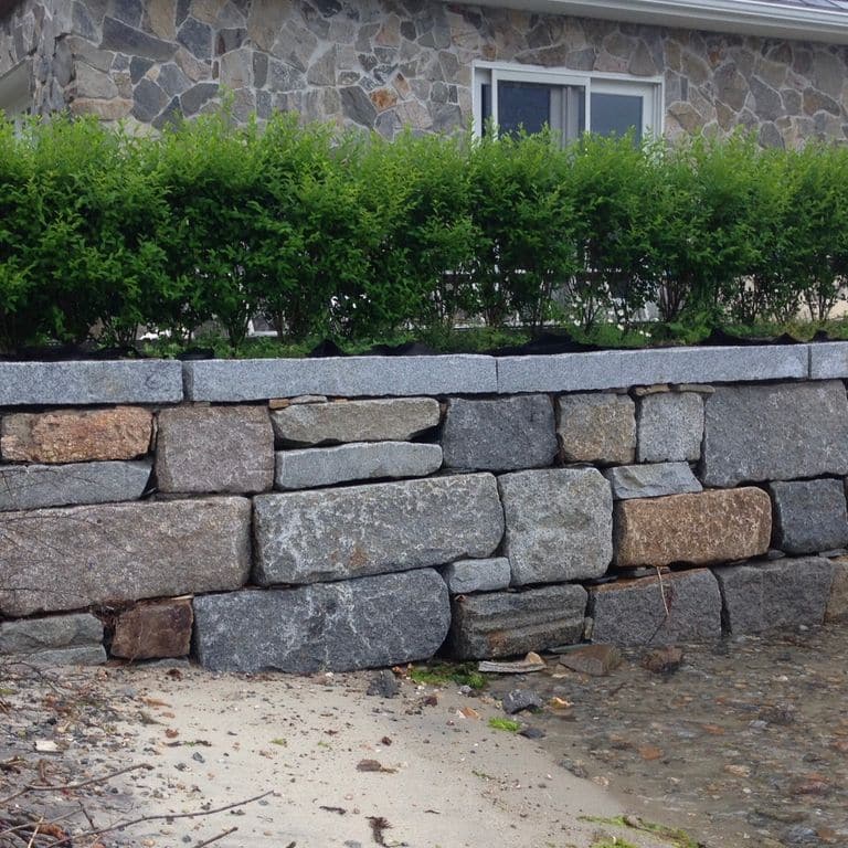 Application image for Test Record - Reclaimed Granite - Wallstone. The image shows this product being used in a landscape wallstone application.