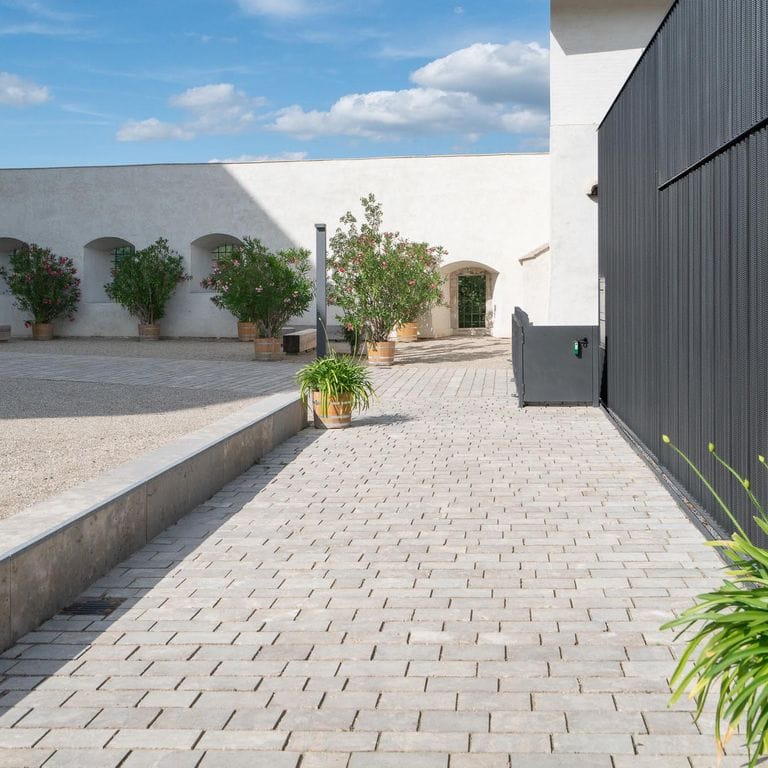 Application image for Bavarian Dolomite Gray Limestone - Sandblasted Cobblestones. The image shows this product being used for path pavers and patio pavers. The surface finish shown is sand blasted. Dominant colors shown are gray and tan. The color mix creates a warm feeling.