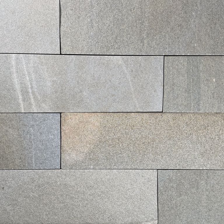 Color/Finish variation image for Heritage Plank Granite - Buff - Plank Pavers. The surface finish shown is split-face. The dominant color shown is gray. The color mix creates a warm feeling.